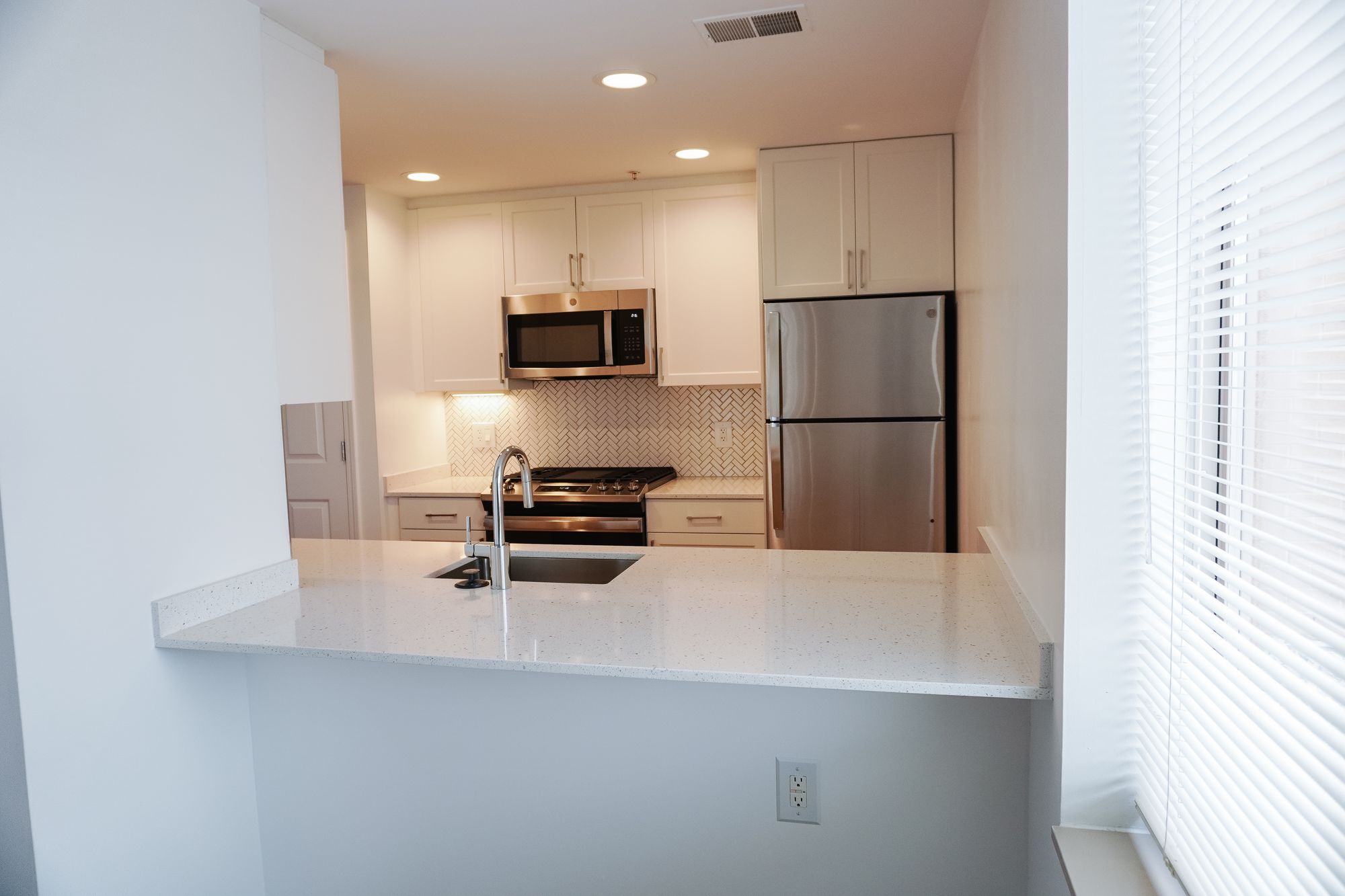 Finished unit kitchen with white cabinets and quartz counters