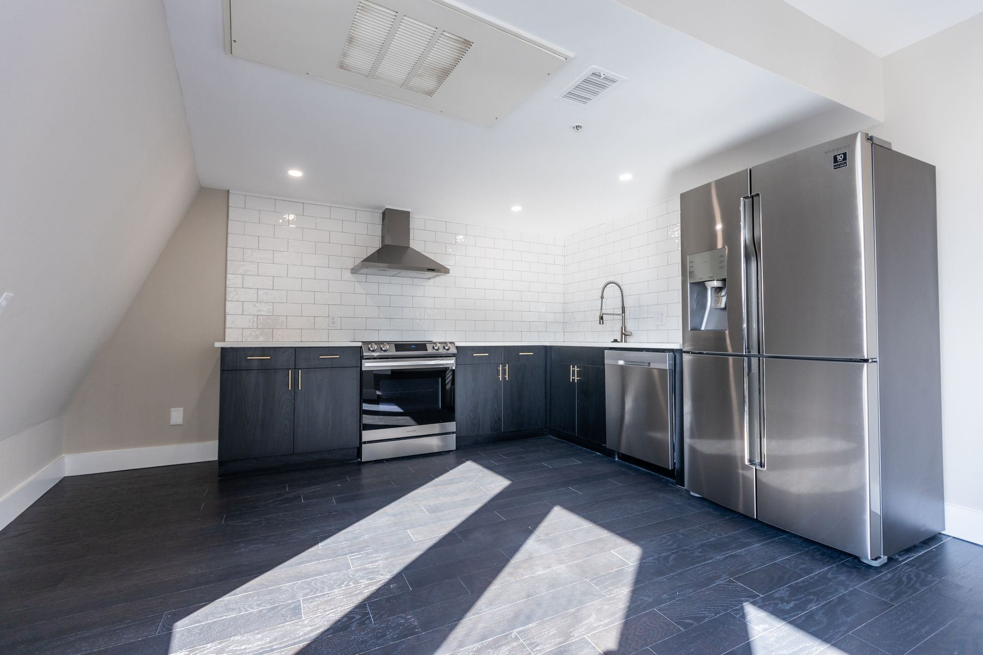 Georgetown Suites renovated kitchen with dark cabinets and stainless appliances